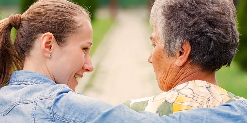 Younger woman with her arm around an older woman  Younger woman with her arm around an older woman